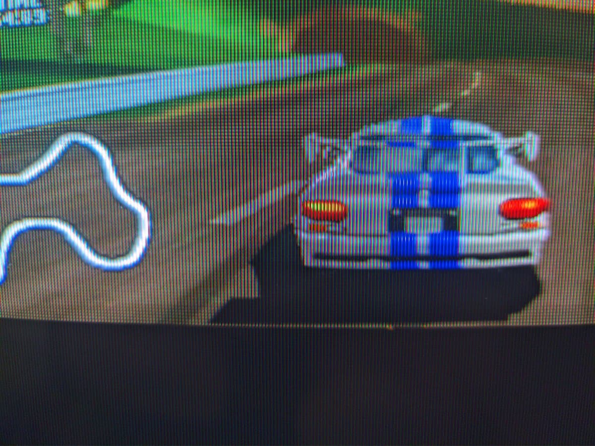 Three Sony PVM-9040 CRT monitors displaying N64 World Driver Championship gameplay in hi-res mode, showing blue race car with red details on track.