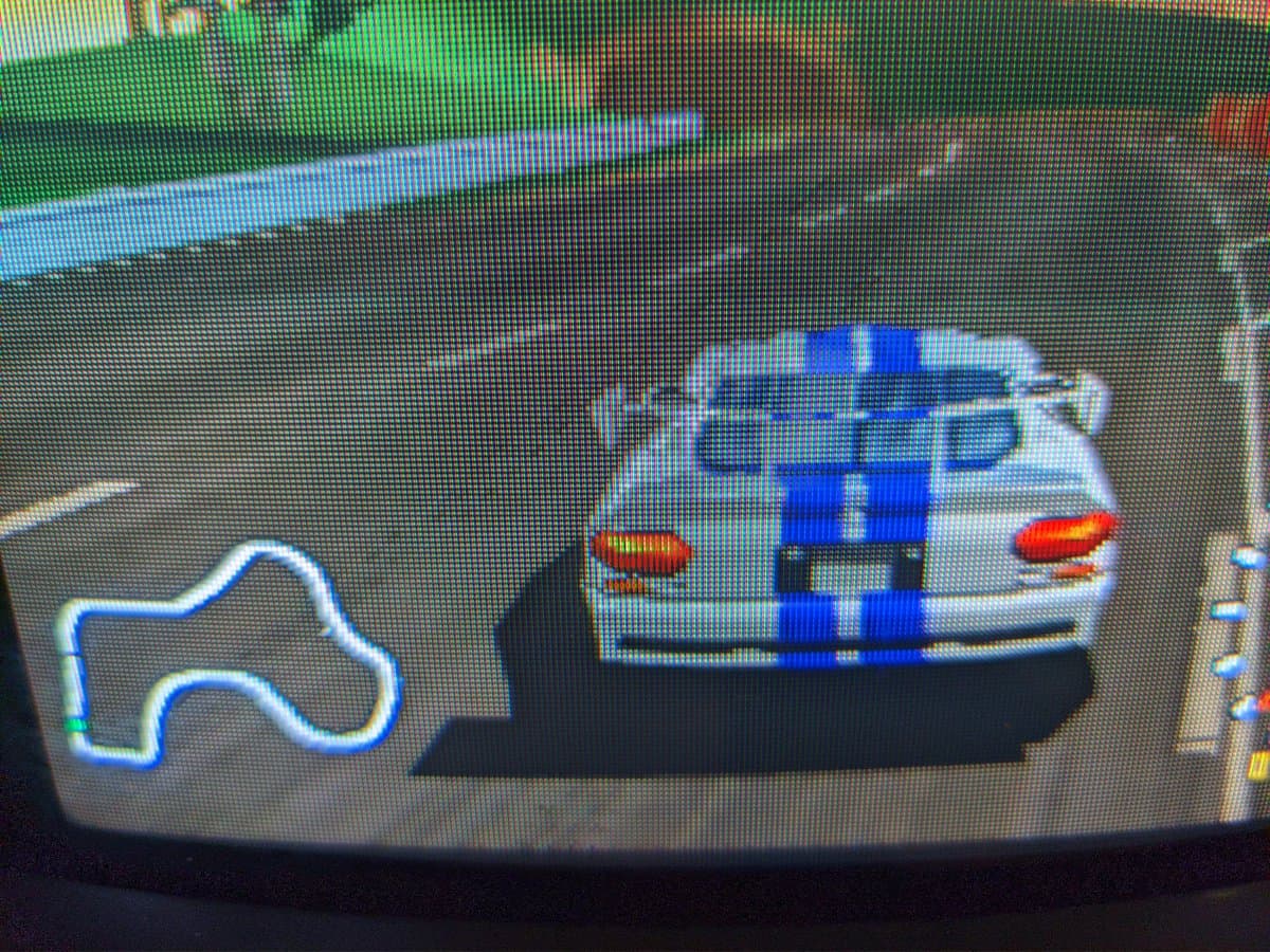 N64 World Driver Championship displayed on Sony PVM-9040 CRT in normal resolution mode; blue and white race car on track with red tail lights visible.