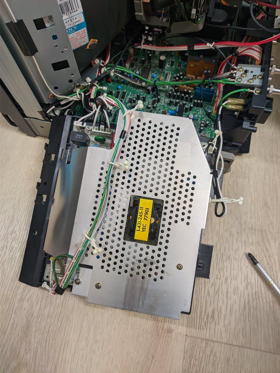 Sony PVM-14M4J power supply with recapped components, yellow transformer visible, green and red wiring, metal chassis with ventilation holes.