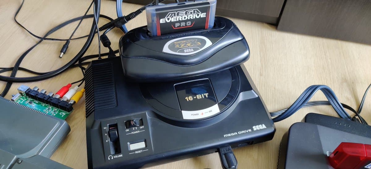 Sega Mega Drive with 32X cartridge inserted, showing internal circuitry and mod board during switchless auto-hertz region modification repair.