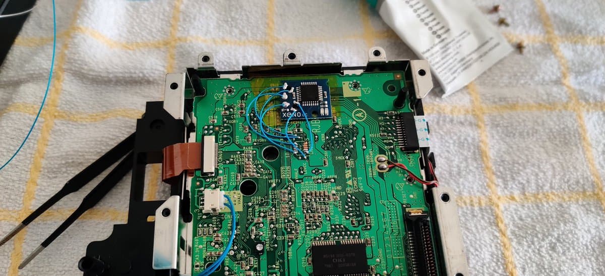 Nintendo GameCube motherboard with Xeno chip installed, showing soldered connections and internal circuitry during refurbishment.