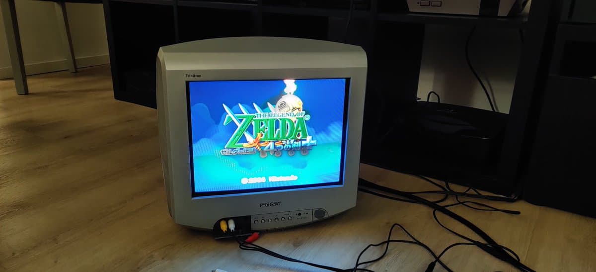 Sony CRT displaying Legend of Zelda: The Wind Waker boot screen, Panasonic Q console undergoing restoration visible below monitor.