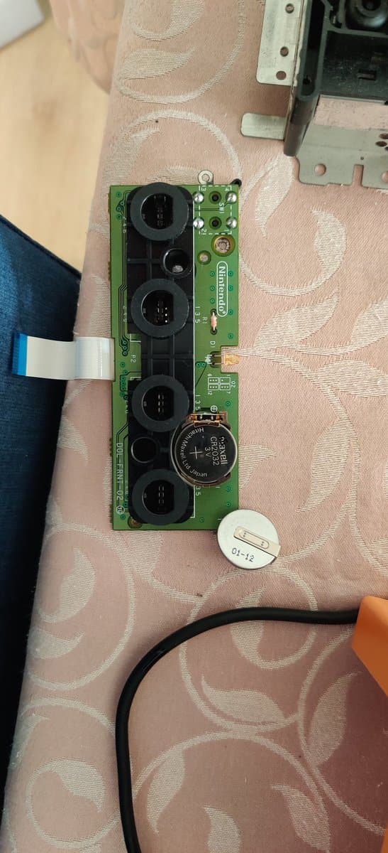 GameCube motherboard with newly installed capacitors and Xeno chip, showing recapped power delivery section and modchip installation work.