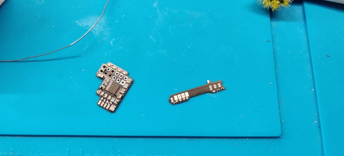 Two PCBs on bright blue workmat: RGB amp board (left) and buddy long board (right) for N64 RGB mod installation.