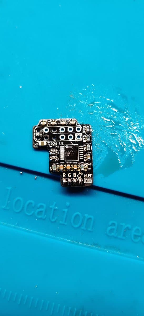 RGB amp PCB cleaned with isopropyl alcohol after hot air rework, video IC installed, components soldered on bright blue surface.
