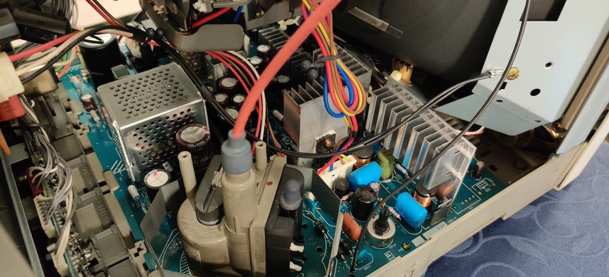 Interior of Sony PVM-14L2 showing clean PCB, capacitors in good condition, power supply components, and colorful wiring harness.