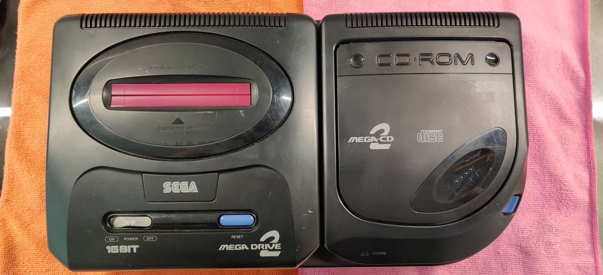 Sega Mega Drive 2 cartridge unit (left) and Mega-CD 2 disc drive unit (right) displayed during restoration work.
