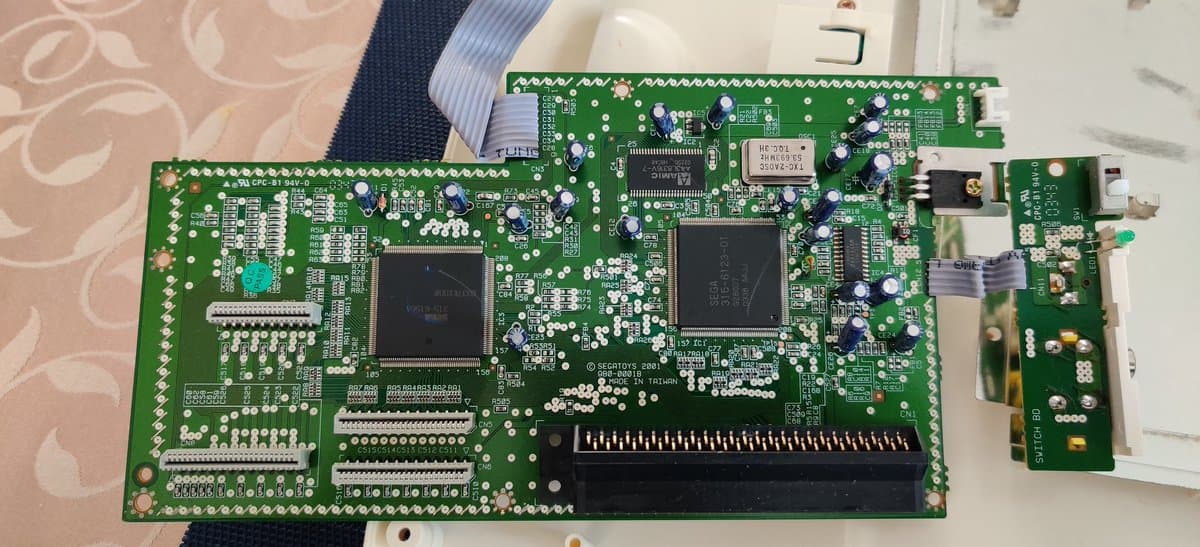 Sega Pico mainboard with new capacitors installed, voltage regulator replaced, and cleaned PCB ready for testing.