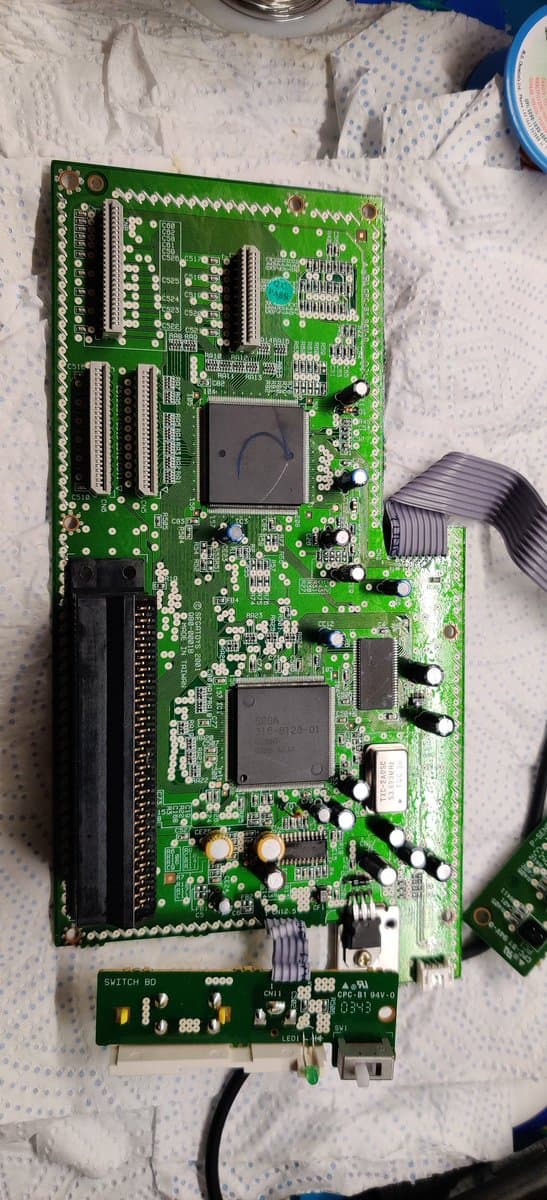 Sega Pico main board with new capacitors installed, showing two large ICs and regulator replacement during recap repair.