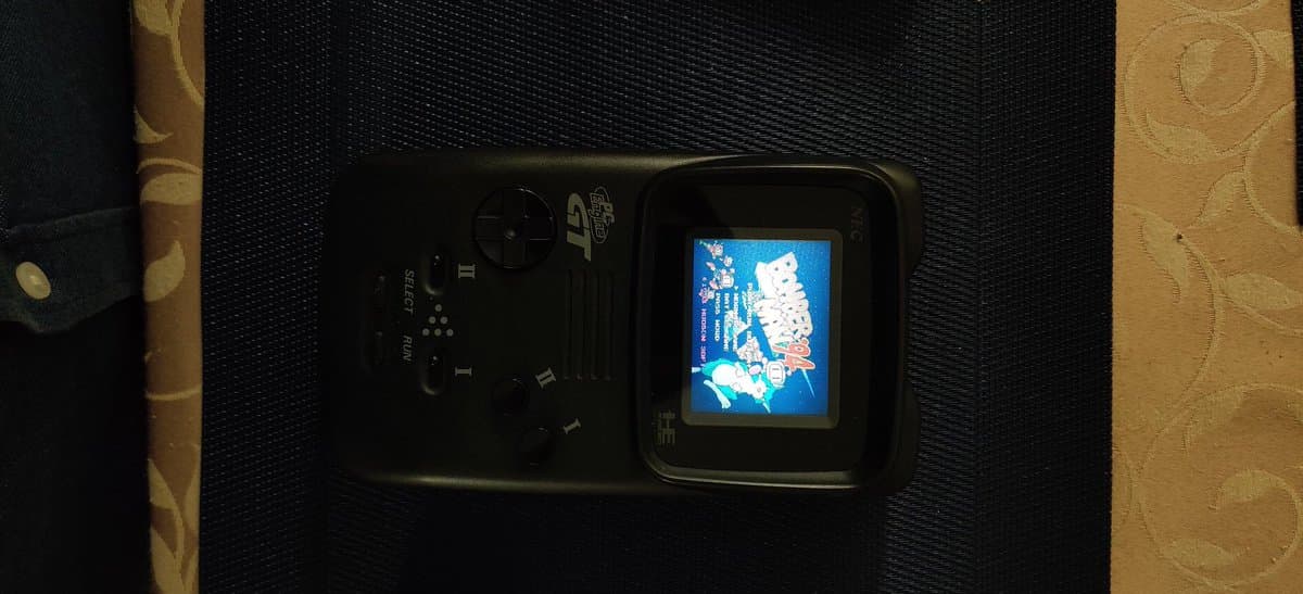 NEC PC Engine GT handheld displaying Bomberman '94 title screen after capacitor replacement and jailbar fix repair.