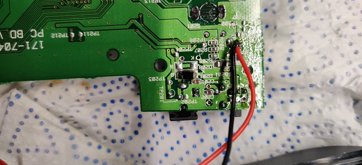 Sega Nomad PCB showing freshly resoldered power jack area with new capacitors installed and cleaned solder joints on nearby components.