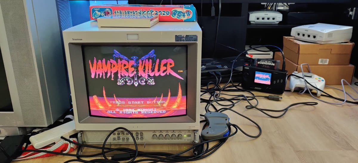 Restored Sega Nomad displaying Vampire Killer arcade game on Sony PVM monitor, connected via RGB cables for testing after repair.