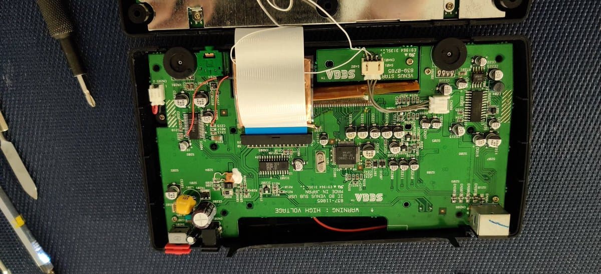 Sega Nomad PCB with audio mod components: 10uF capacitors and 10k resistors soldered for Master System/Mega-CD audio restoration.