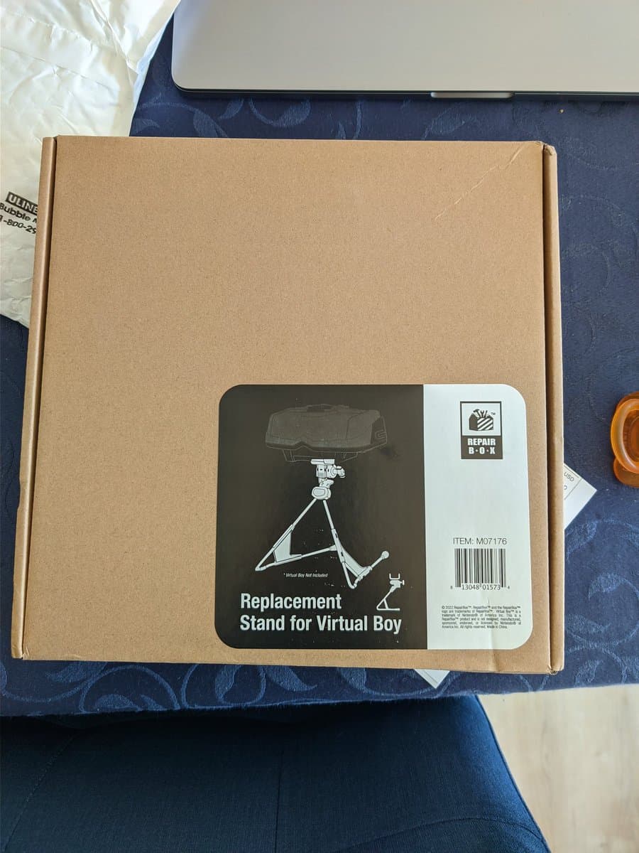 Repair Box replacement stand for Virtual Boy in cardboard packaging, item M07176, showing assembly diagram on box label.