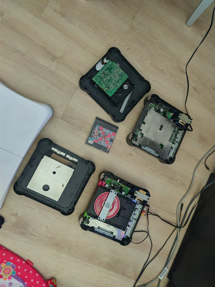 Disassembled Panasonic FZ-1 3DO consoles showing exposed circuit boards, PSU repairs, laser mechanisms, and internal components laid out for restoration work.