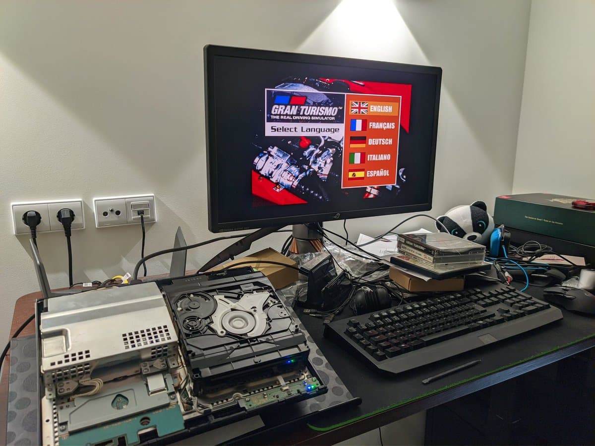 Disassembled PS3 CECHB00 showing internal components, laser assembly, and disc drive mechanism on work surface during TLC repair.