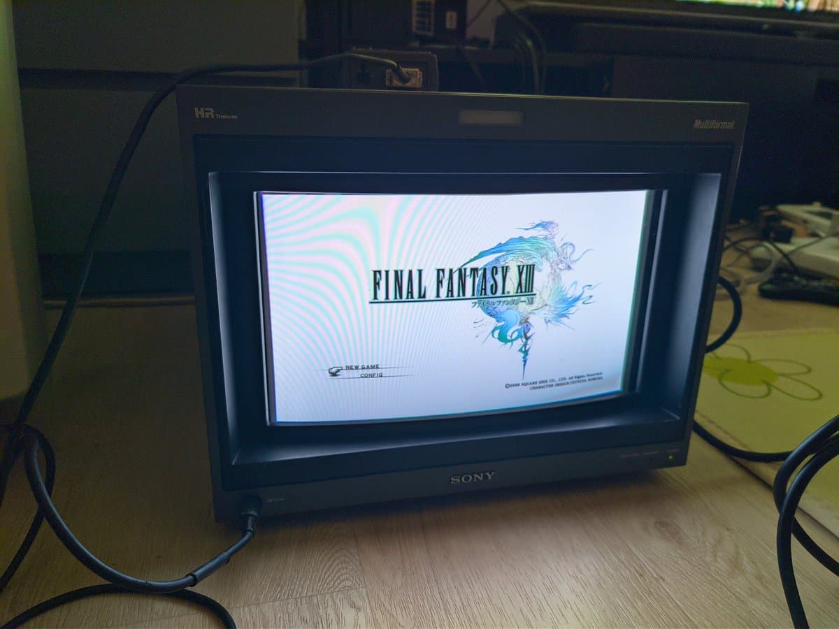 Final Fantasy XIII title screen displaying on restored Sony BVM-D14H1E professional CRT monitor with blue striped pattern background visible.