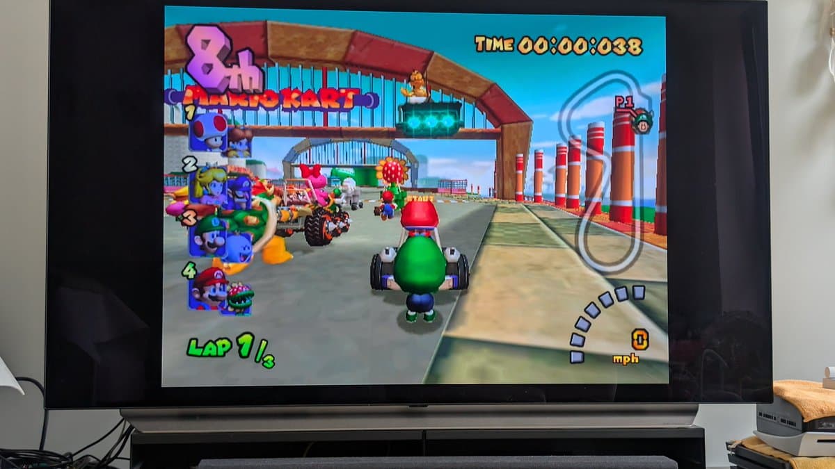 Mario Kart: Double Dash gameplay on restored Panasonic Q, showing start line at Luigi Circuit with green Yoshi kart ready to race.