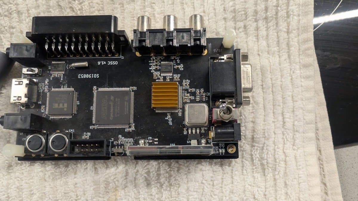OSSC classic circuit board with modded firmware chip, showing CPU, RAM, video processor ICs, and composite/RGB connectors during upgrade work.