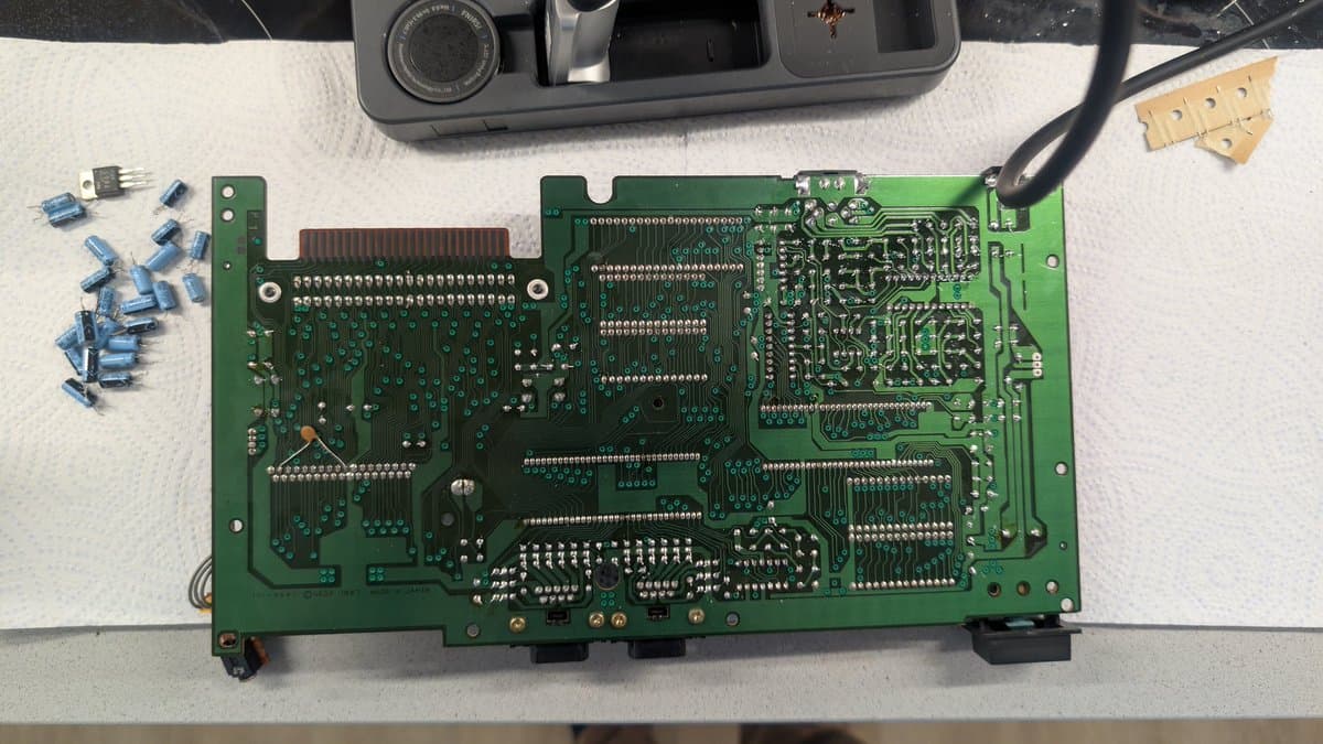 Sega Master System MK-2000 mainboard with removed capacitors and components laid out during refurbishment repair work.
