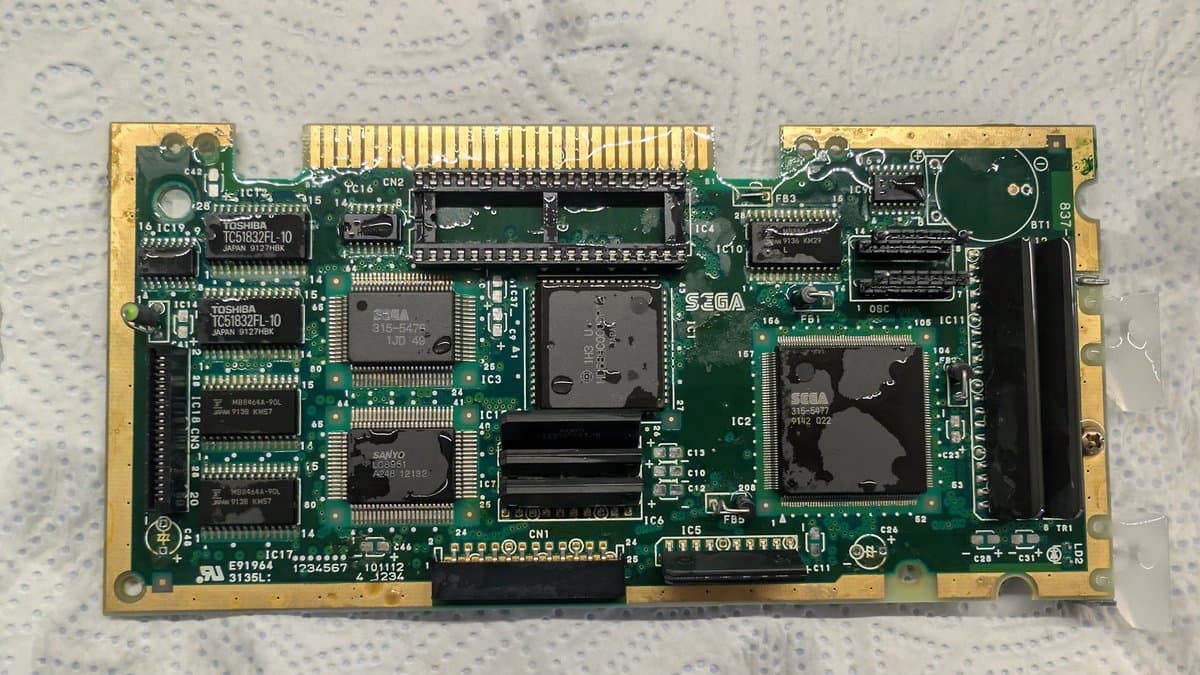 Sega Mega-CD 1 motherboard with multiple leaked capacitors, showing corrosion and damage across the PCB during restoration and recap process.