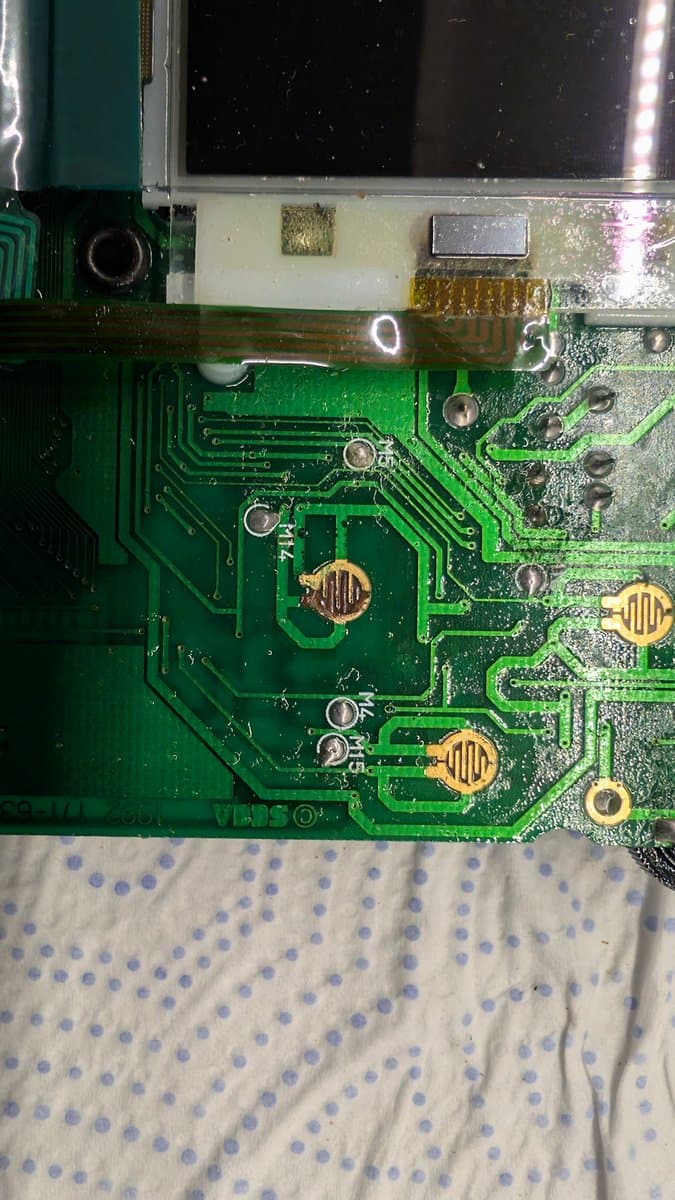 Sega Game Gear main board cleaned, showing corrosion damage from capacitor leakage around button pad contacts and various resistors needing replacement.