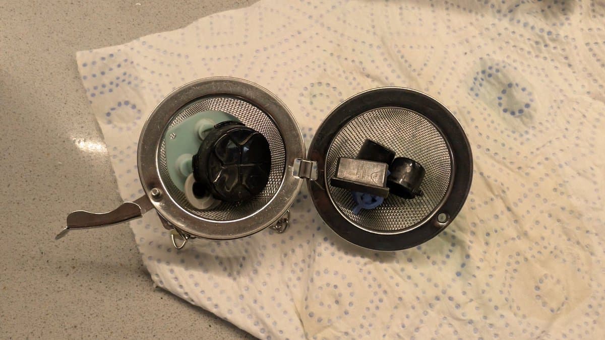 Two disassembled Sega Game Gear speaker domes on paper towel, left showing internal components, right displaying replacement speaker unit.