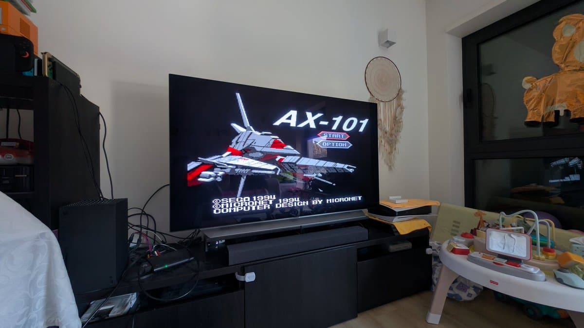 Sega AX-101 arcade game booting on TV, displaying title screen with red and white fighter jet, confirming successful Mega-CD 1 laser replacement and optical pickup repair.
