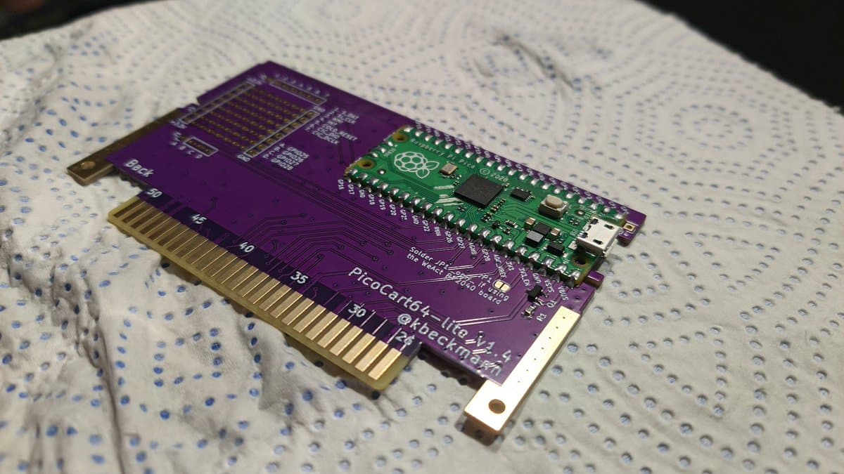 PicoCart64 lite flash cart assembly showing purple PCB with Raspberry Pi Pico microcontroller mounted on green daughterboard, gold cartridge connector pins visible.