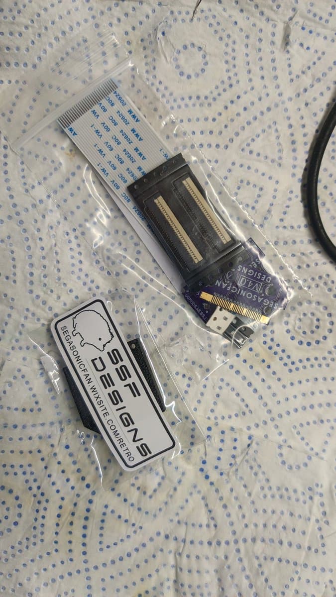 Virtual Ribbon 4.0 kit and mounting jig in packaging, showing connector assembly and installation documentation for Virtual Boy repair.