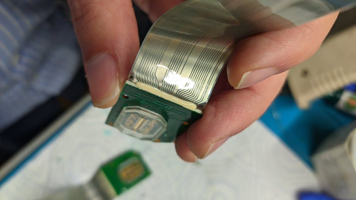 Peeling separated ribbon cable from LED array PCB during Virtual Boy refurbishment, showing delicate adhesive removal process.