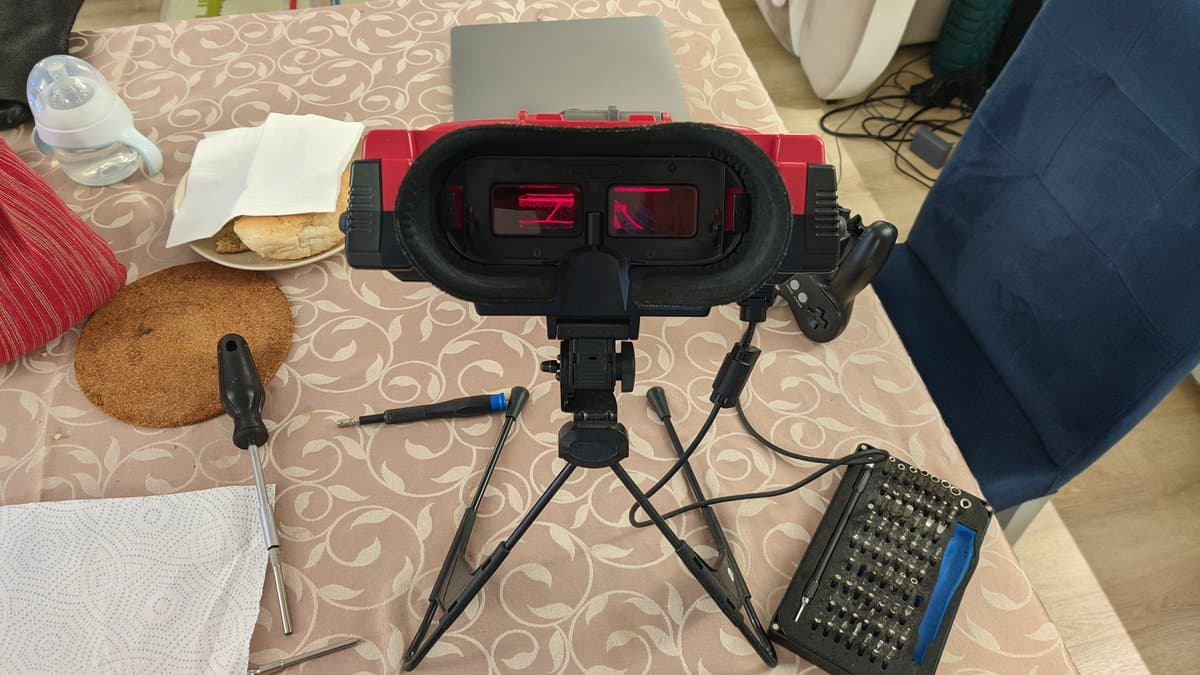 Virtual Boy with disassembled optics and PCBs positioned on workmat during Virtual Ribbon 4.0 installation, showing LED arrays and soldering setup.
