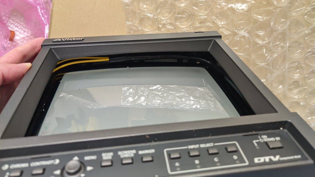 Victor TM-A101 CRT monitor with shattered screen interior visible, yellow and black power cable exposed, damage from shipping incident.