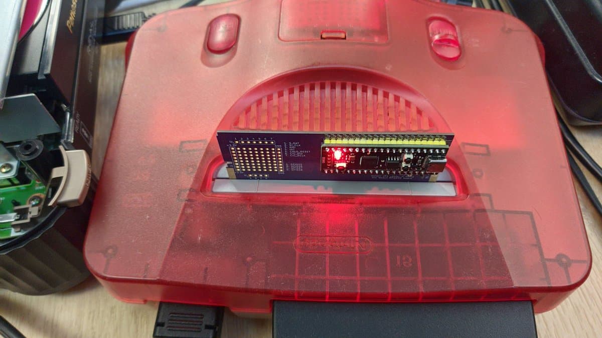PicoCart64 lite N64 flash cart with upgraded Raspberry Pi Pico (16MB flash) installed in red translucent cartridge shell.