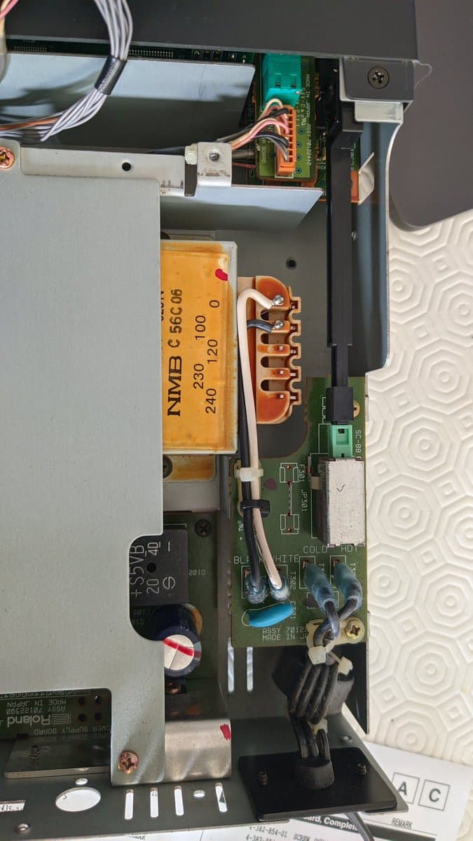 Interior of Roland SC-88 showing NIMB C 56C06 transformer with multiple voltage taps and black wire ready for soldering to select correct input pin.