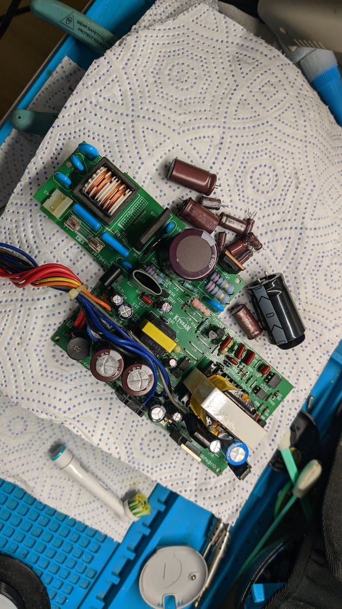 Sharp X68000 Pro II power supply board with replaced components, large capacitors, transformers, and photo coupler visible after accidental probe short during voltage testing.