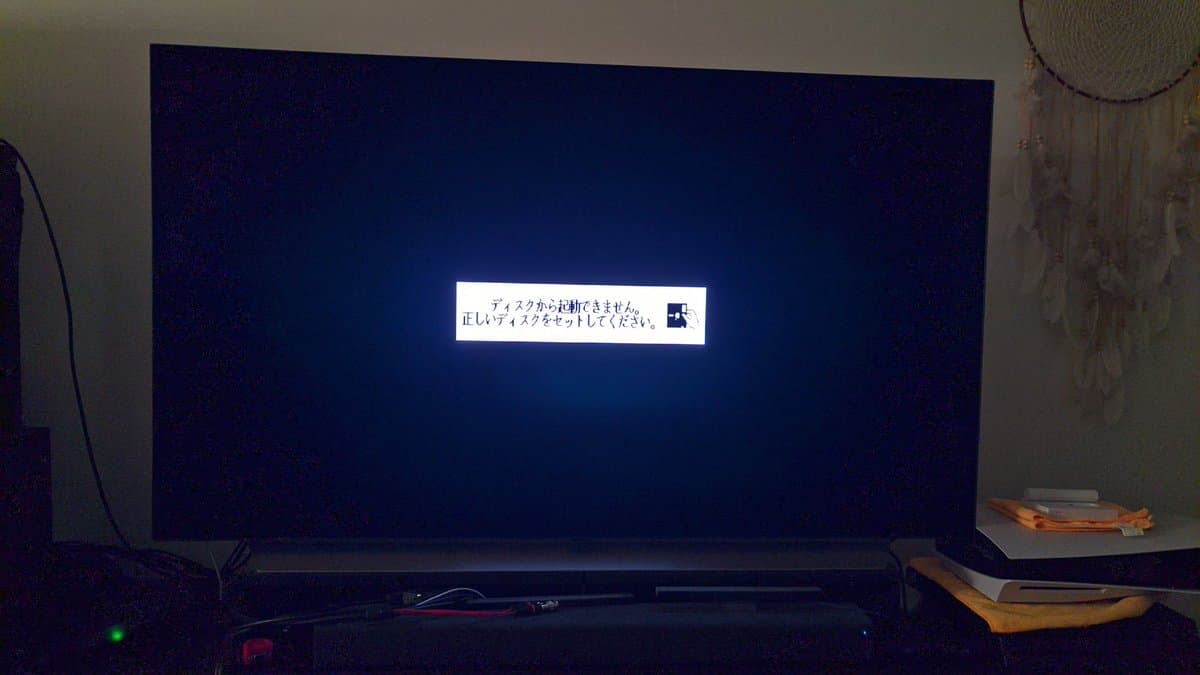 Sharp X68000 Pro II displaying Japanese boot error message on monitor; system powered on after restoration work.