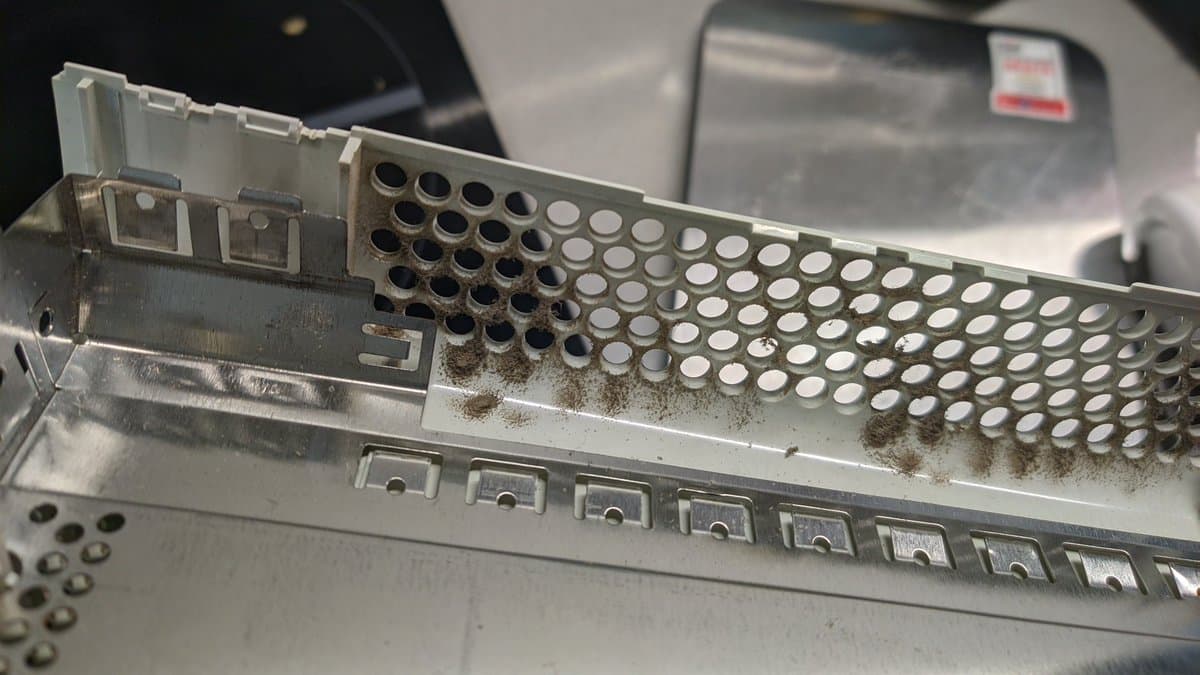 Xbox 360 optical drive laser assembly showing dust accumulation and corrosion on internal components and contacts.