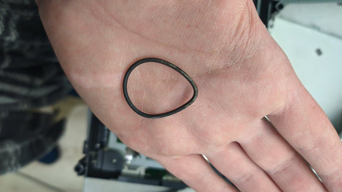 Close-up of a hand showing a simple black oval outline drawn on the palm, likely indicating laser lens location or replacement point on Xbox 360 drive.