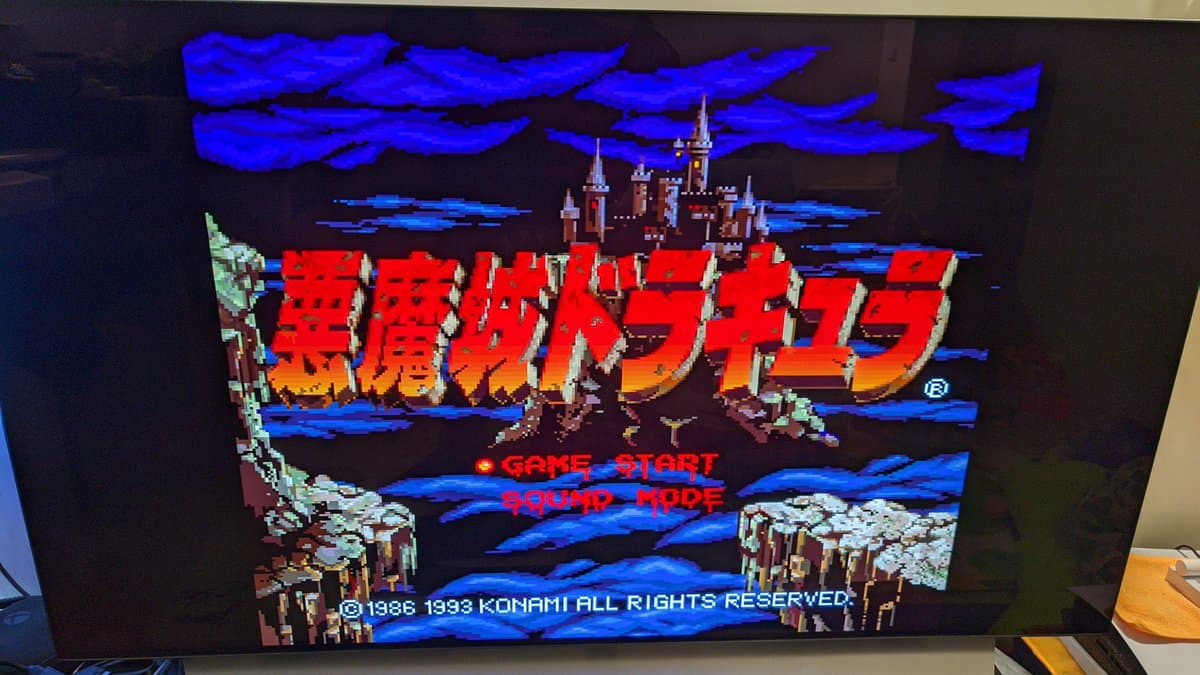 Sharp X68000 Pro II displaying Castlevania title screen with Japanese text, castle and blue sky pixel art, testing restored hardware after component replacement repairs.