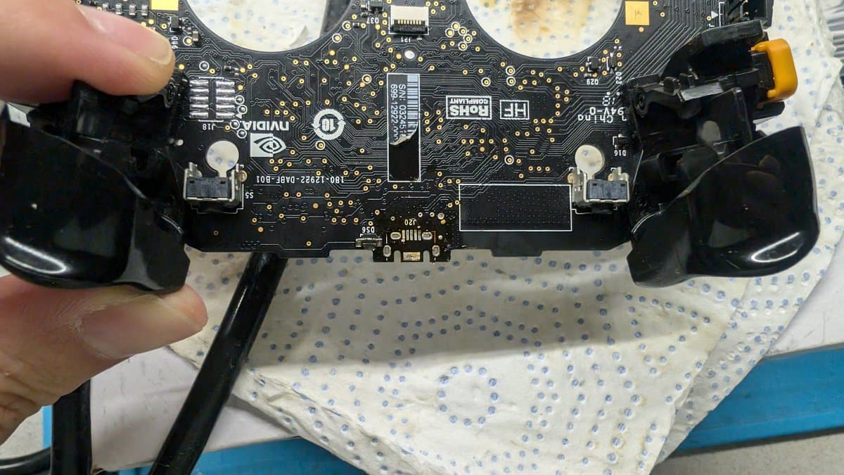 Nvidia Shield controller PCB with replaced USB port installed, showing solder joints and connector footprint on black circuit board.