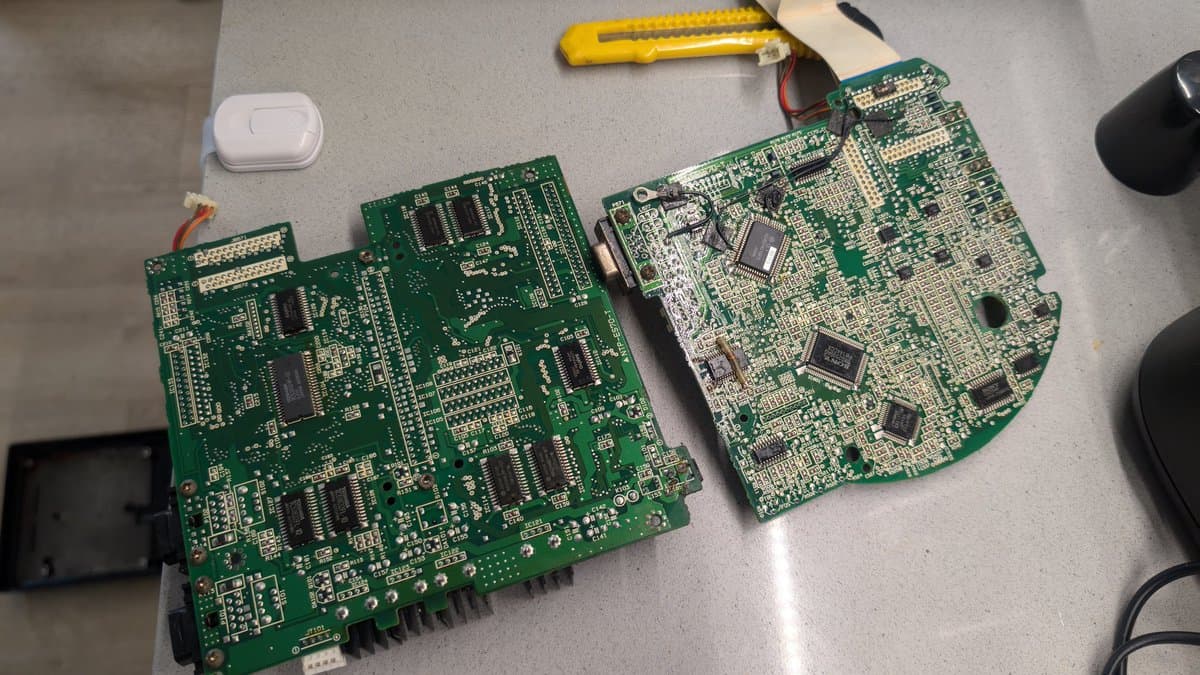 Two Wondermega circuit boards side-by-side after cleanup; left board shows corrosion damage, faded regulator component, and possible broken traces; right board appears in better condition.