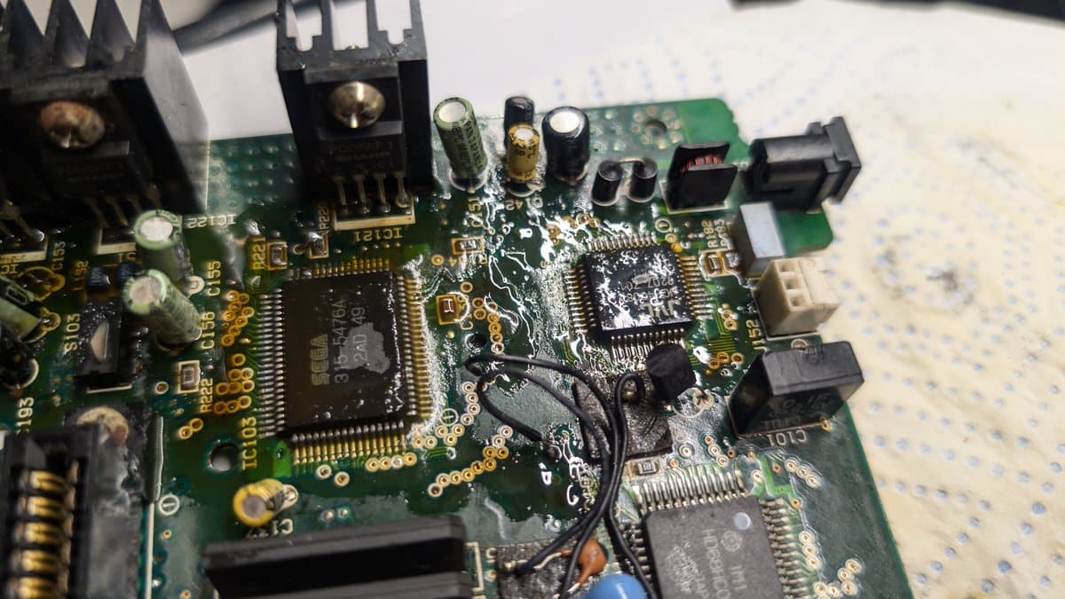Sega Wondermega circuit board with heavy corrosion damage, leaking capacitors, and deteriorated solder joints requiring restoration.