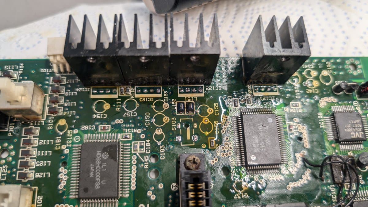 Sega Wondermega board with multiple solder joints being reflowed using tacky flux to remove water damage and electrolyte corrosion from through holes.