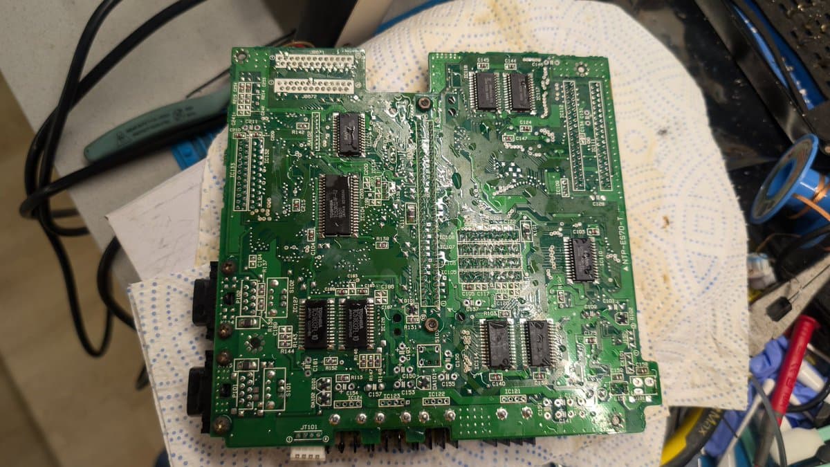 Cleaned Wondermega mainboard after ultrasonic bath, showing exposed circuitry, ICs, and solder joints ready for continuity testing.