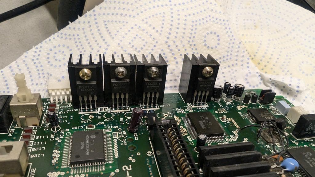 Voltage regulators removed from Wondermega board, legs tinned; electrolytic capacitors in progress of replacement during restoration.