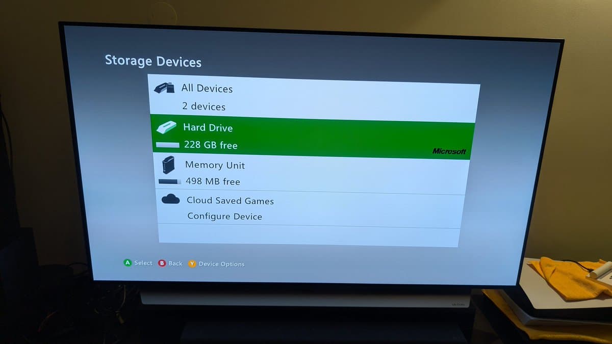 Xbox 360 E Storage Devices menu showing Hard Drive with 228 GB free space and Memory Unit with 498 MB free.