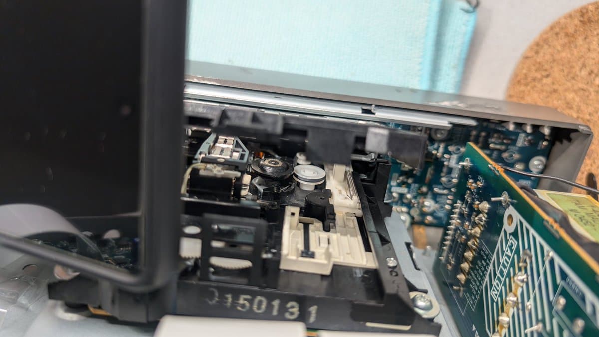 Interior of MiniDisc deck showing loading mechanism with replacement belt installed, circuit board visible on right side, serial number 3150131 marked on chassis.