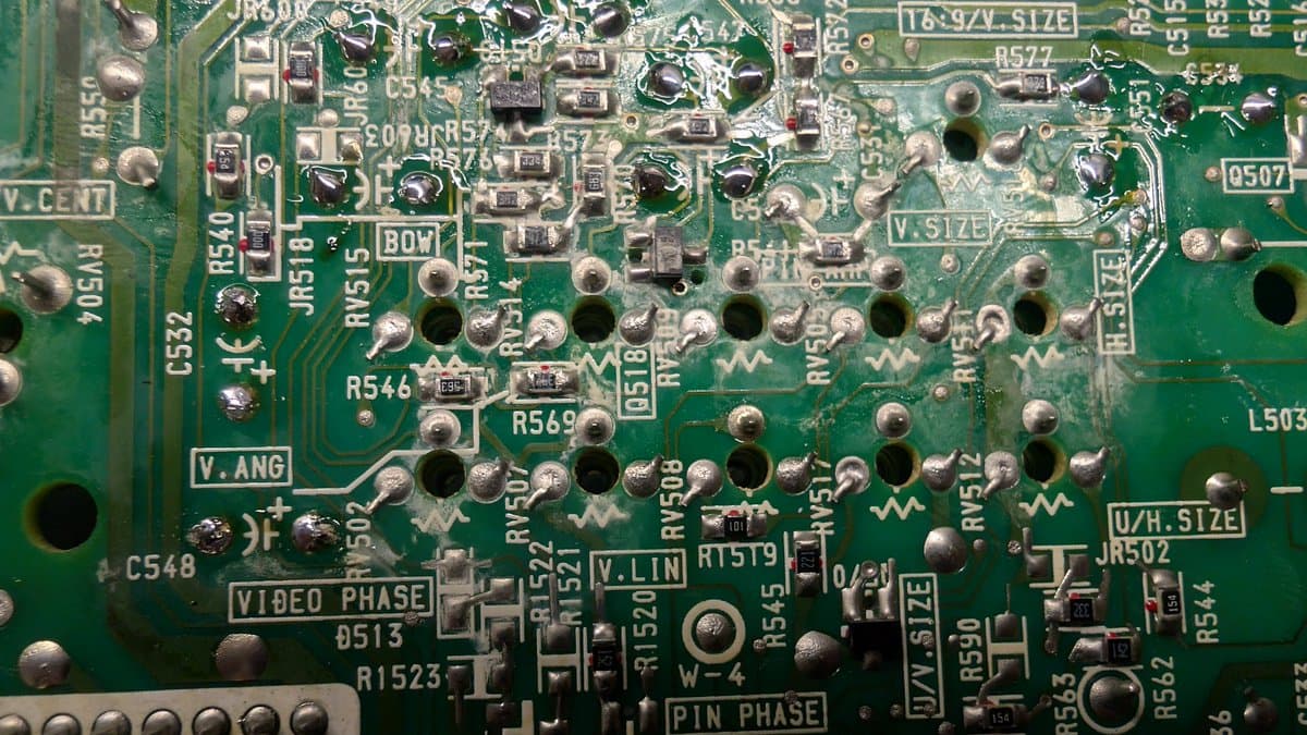 Close-up of Sony PVM-9041Q deflection board showing corroded solder joints, component labels (R546, R569, C548, VIDEO PHASE, PIN PHASE), and oxidized solder requiring reflowing during restoration.