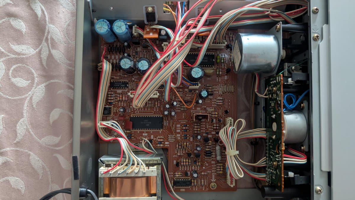 Sony TC-FX66 main circuit board with blue capacitors, transformers, and ribbon cables; interior appears clean with no visible damage or corrosion.
